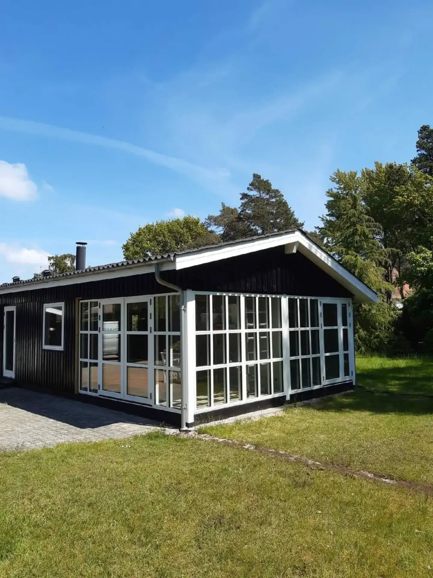 Moderne træhus med store vinduespartier til naturligt lys og åben atmosfære.